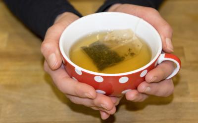 Hände die eine Teetasse halten