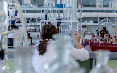 Frau hantiert mit Chemikalien im Labor