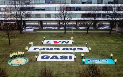 Banner mit der Aufschrift "EVN raus aus Gas!" liegen auf der Wiese vor dem EVN Gebäude