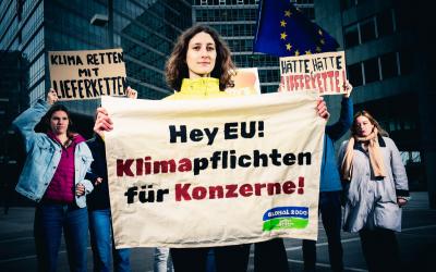 Anna Leitner hält Banner mit "Klimapflichten für Konzerne" in der Hand