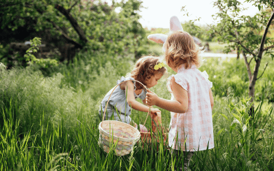Zwei Mädchen auf der Suche nach Ostereiern im hohen Gras
