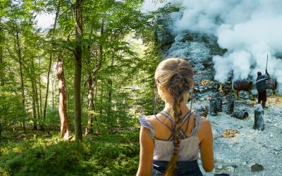 Kind steht in der Mitte von Hinten sichtbar. Bild in zwei geteilt: rechts ein warmes Bild eines Waldes, links ein Arbeiter beim Schwefelabbau mit Rauchentwicklung, sehr düster.