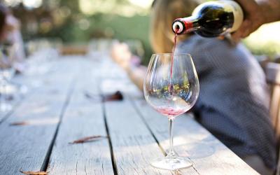 Rotwein wird in ein großes Weinglas geschenkt