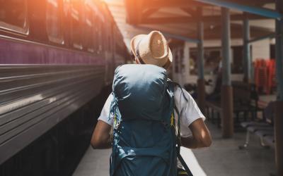 Person mit Rucksack und einfahrendem zug