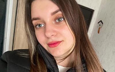 Ein Mädchen mit rotem Lippenstift, Grüne  Lange Braune Haare und Schwarzer Jacke 