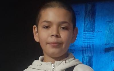 Junge mit weißem Pullover und kurzen Haare 