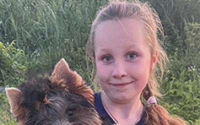 Mädchen mit Zopf und Hund im arm