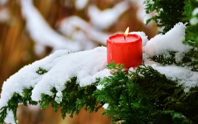 Kerze brennt auch Tanne mit Schnee