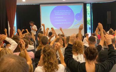 Schüler:innen zeigen auf in Multivisions-Vortrag