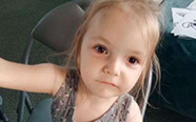 Kleines Kind das am Tisch sitzt