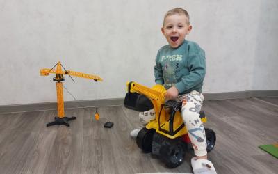 Junge spielt mit Bagger-Spielzeug und freut sich