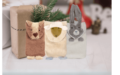 3 Wärmflaschen in Tierform vor weihnachtlichem Hintergrund