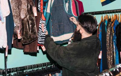 Mann sieht sich Kleidung in Secondhand-Shop an