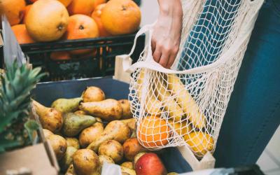 Einkaufsnetz wird im Supermarkt mit Gemüse gefüllt