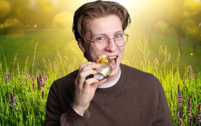 Junge beißt bei Schoko-Osterhasen ab, Fotomontage vor frühlingshaftem Hintergrund