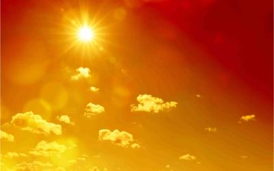 Sonne scheint auf einem rot-orange glühenden Himmel mit ein paar Wolken