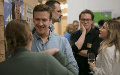Gruppe von Personen bei einem Event mit GLOBAL 2000-Plakaten im Hintergrund