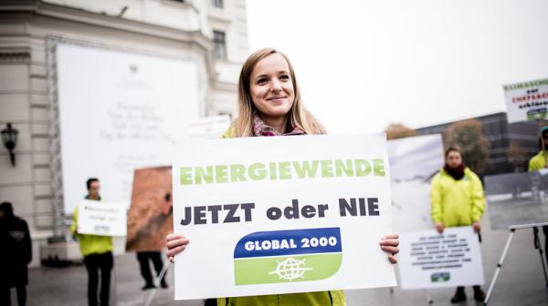 Aktivistin trägt Protestschild "Energiewende jetzt oder nie"