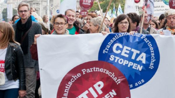 Menschen bei der TTIP Demo 2014 mit Banner auf dem "TTIP Stoppen" und "CETA Stoppen" steht