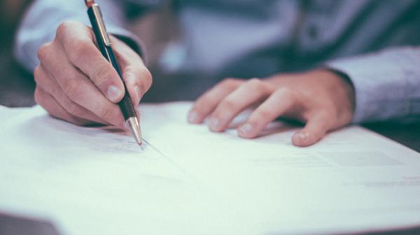 Mann schreibt auf Dokumenten