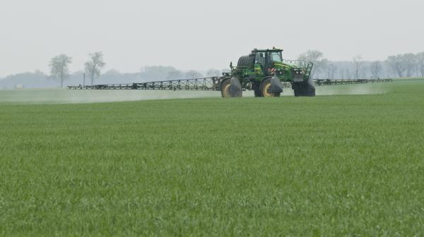 Traktor der Pestizide am Feld ausbringt