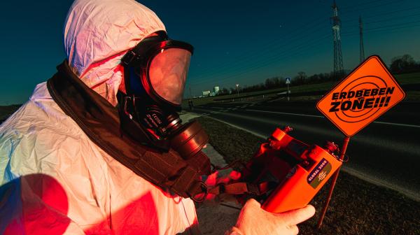 Mann in Schutzanzug mit Geigerzähler vor AKW Krsko