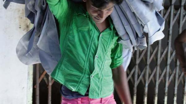 Mann mit vielen Kleidungsstücken über der Schulter