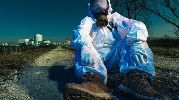 Mann sitzt vor dem Krsko-Reaktor