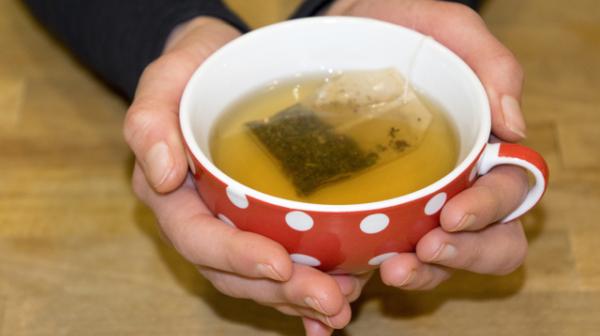 Hände die eine Teetasse halten