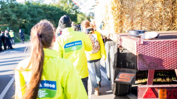 GLOBAL 2000-Aktivist:innen gehen neben Traktor