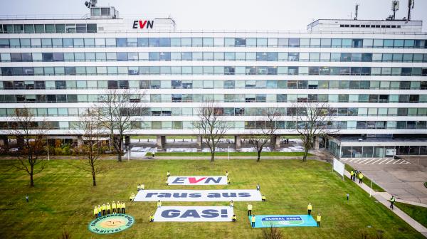 Banner mit Aufschrift "EVN – Raus aus Gas!" auf einer Wiese vor dem EVN-Hauptgebäude