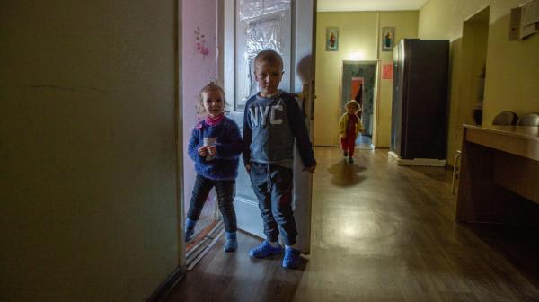 Zwei Kinder schauen neugierig aus dem Zimmer 