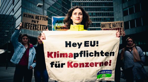 Aktionsfoto für den Earth Day mit einem Banner "Klimaplichten für Konzerne"
