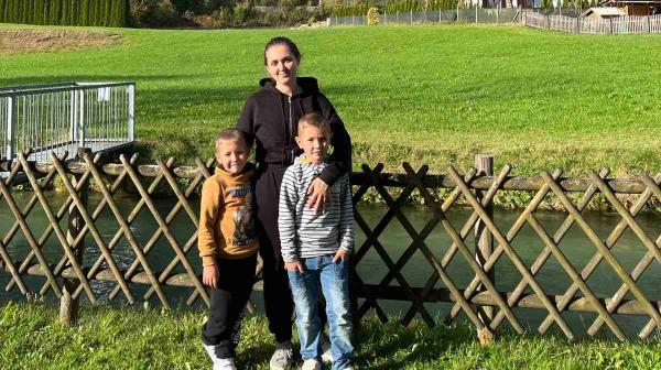 Oksana mit ihren beiden Kindern vor einem Berg