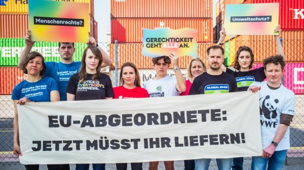 Aktion zum Lieferkettengesetz mit einem Banner auf dem steht: EU-Abgeordnete - Jetzt müsst ihr liefern!