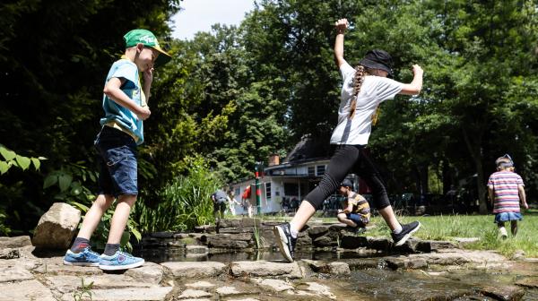 Kinder tollen an einem Teich