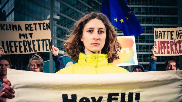 Aktionsbild für Lieferkettengesetz, zentral im Bild ist Anna Leitner, die Ressourcensprecherin von GLOBAL 2000