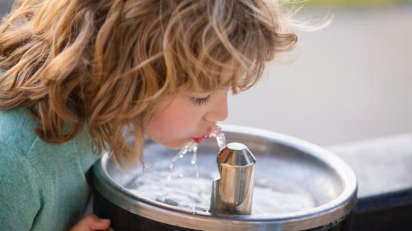 Kind trinkt aus Trinkwasserspender