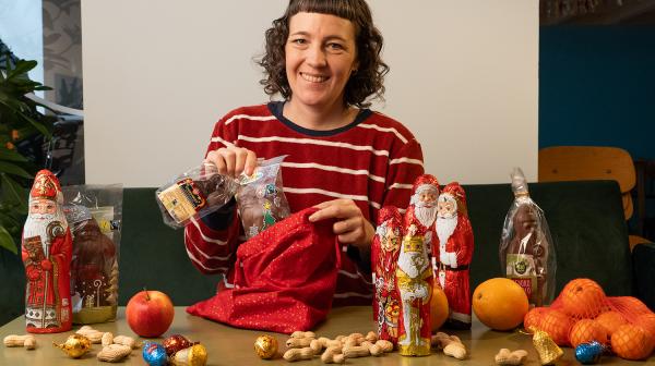 Frau im rot-weiß-gestreiften Shirt steckt Schoko-Nikoläuse in einen Nikolo-Sack.