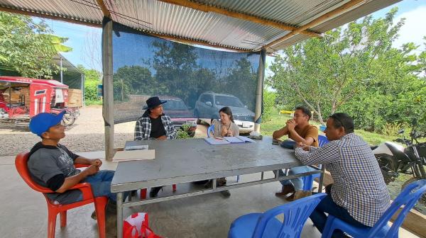 Menschen sitzen um einen Tisch, Untersuchung Bio-Bananen Plantage Peru