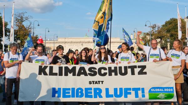viele Menschen halten ein Transparent auf dem steht: Klimaschutz statt heisser Luft.