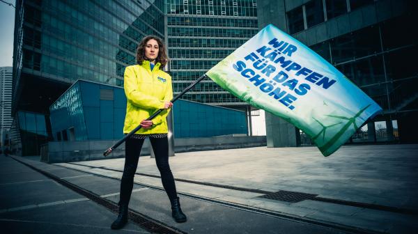 Anna Leitner mit Fahne auf der steht: Wir kämpfen für das Schöne.