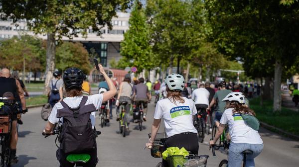 Bild einer Fahrrad-Demo, im Vordergrund drei Personen auf Fahrrädern mit GLOBAL 2000 T-Shirts