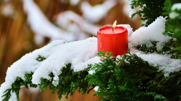 Kerze brennt auch Tanne mit Schnee