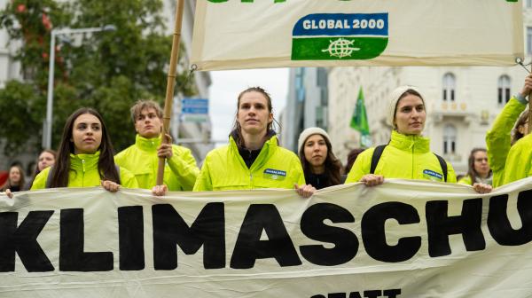 Klimastreik: Menschen gehen mit Banner auf dem Klimaschutz steht