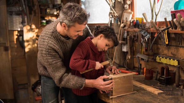 Vater lernt Tochter Handwerk, sie zimmern gemeinsam in Werkstatt