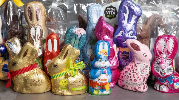 Viele Osterhasen stehen zusammen auf dunklem Hintergrund