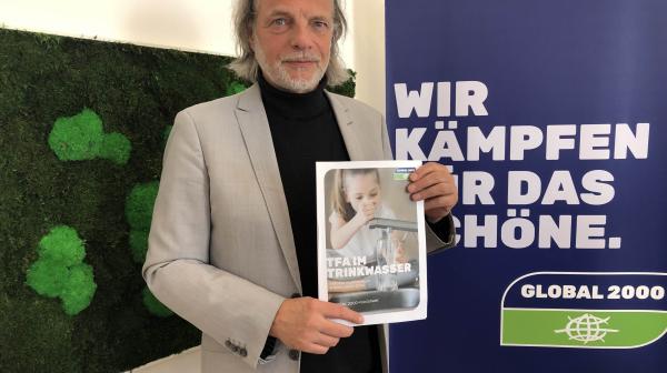 GLOBAL 2000 Experte Helmut-Burtscher Schaden hält das Factsheet zur TFA-Untersuchung mit dem Titel "TFA im Trinkwasser" in den Händen.
