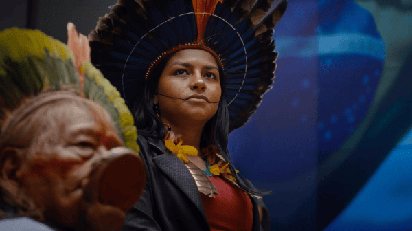 Filmsujet von Yanuni: Zwei Personen mit traditionellen Kopfschmuck und bunter Kleidung vor einem unscharfen Hintergrund
