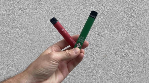 Eine Hand hält zwei Einweg-Vapes.